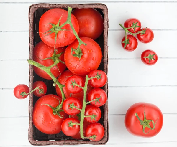 Tomatoes with drops on basket — Stock Photo, Image