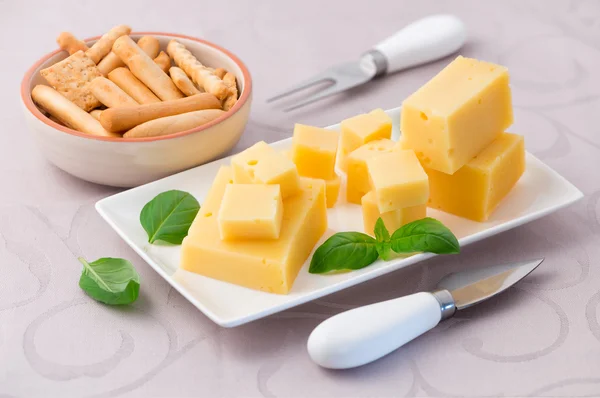 Cheese and basil leaves on the table — Stock Photo, Image