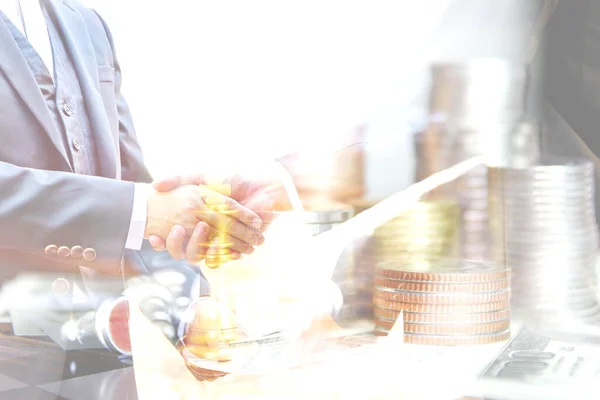 double exposure business men hand shake with coins stacking on Amrican dollar bank note , business concept