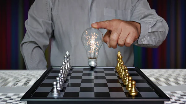 Worker Touching Light Bulb Chess Board Golden Silver Chess Pieces — Stock Photo, Image