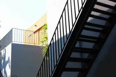 Açık hava siyah çelik merdivenler yan binaya kurulur.
