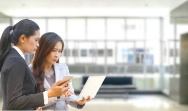 Elde cep telefonu tutan genç bir işçi dizüstü bilgisayarla çalışan üst düzey bir işçiyle konuşurken internetle ilgili ciddi bir ilişki kurulamıyor.