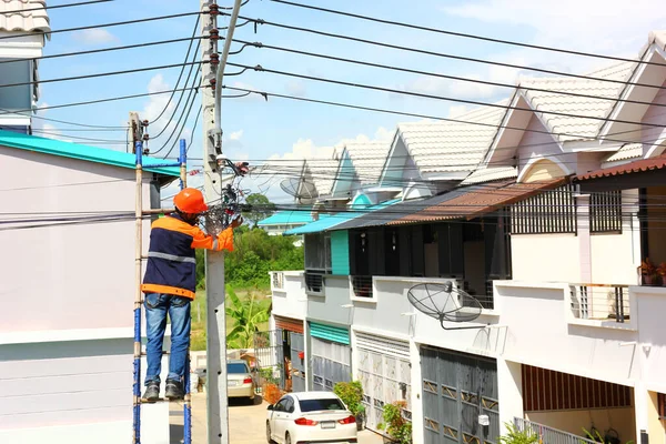 the technician of internet service provider is checking fiber optic cables after install on electric pole or after being notified of a problem in use