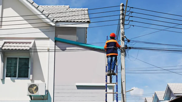 the technician of internet service provider is checking fiber optic cables after install on electric pole or after being notified of a problem in use