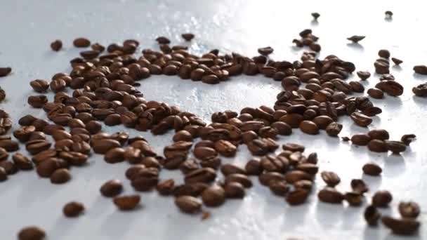 Σκορπισμένοι Κόκκοι Καφέ Στριφογυρίζουν Στο Τραπέζι Σχηματισμένο Σχήμα Καρδιάς Από — Αρχείο Βίντεο