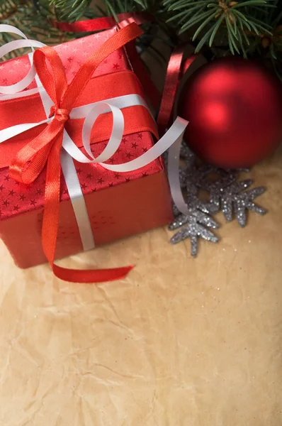 Caixa de presente de Natal e ornamentos no fundo de papel velho — Fotografia de Stock