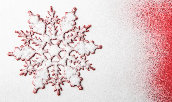 Vánoční vločka obrazec na sněhu s červeným pozadím — Stock fotografie
