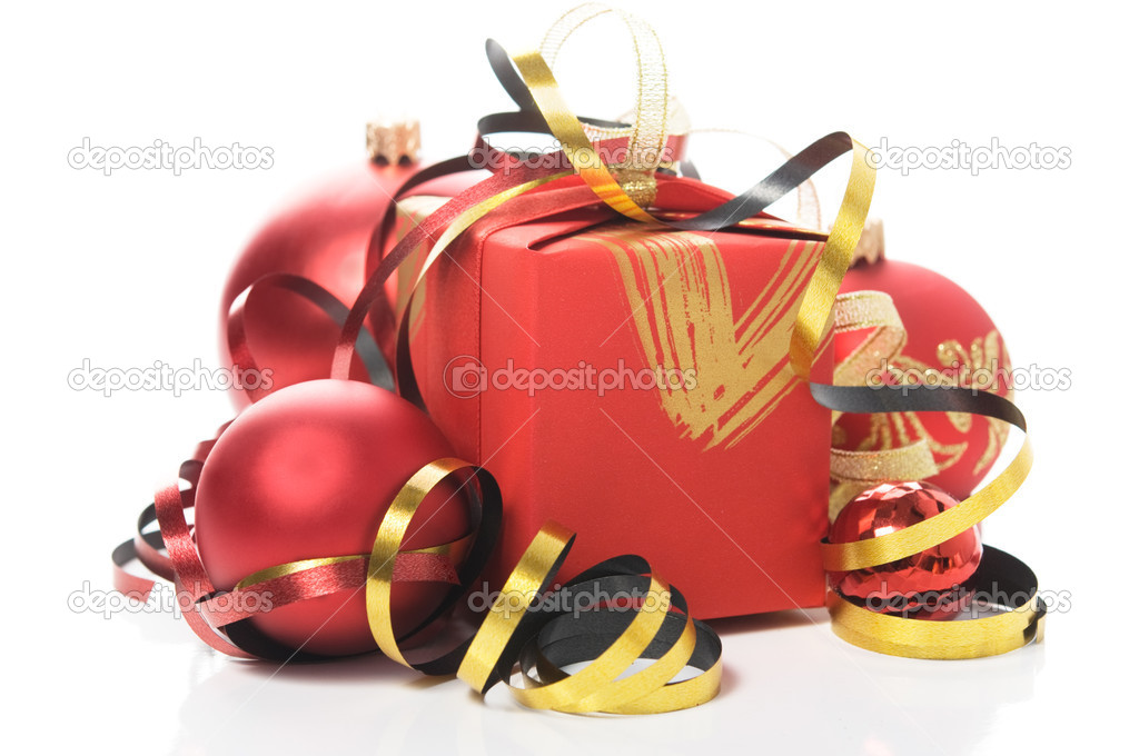Red gift box with colorful ribbons and xmas baubles on white background