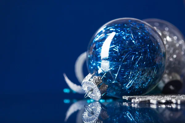 Blue and silver xmas ornaments on dark blue background — Stock Photo, Image