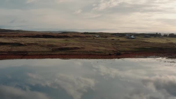 Drone volando sobre todavía tranquilo lago reflectante durante el amanecer en la Isla de Skye — Vídeos de Stock