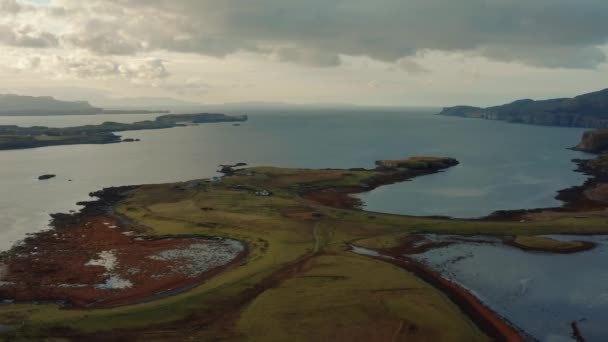 Drone survolant un lac encore calme et réfléchissant au lever du soleil sur l'île de Skye — Video