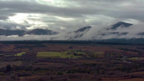 Ben Nevis mountain range surrounded by clouds at sunrise - aerial footage 4k — стоковое видео