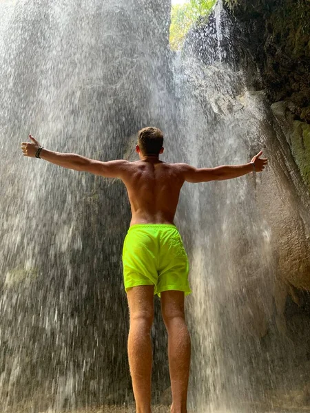 噴水で手を上げている男 男は手を空に伸ばしている 水源の男だ — ストック写真