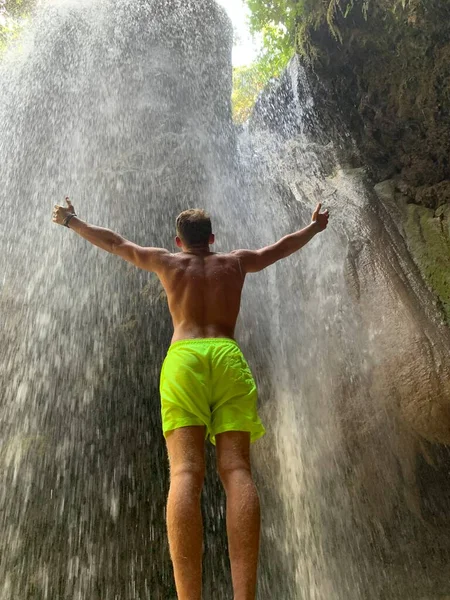 噴水で手を上げている男 男は手を空に伸ばしている 水源の男だ — ストック写真