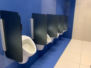 Modern pisyuar erkekler tuvaletinde. Eğlence merkezindeki erkekler için tuvalet. Bölmeli umumi tuvalet..