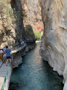 Yüksek bir kaya vadisi ve dağ nehri. Nehir boyunca derin dar bir kanyon. Türkiye 'yi gezmek, turistler için gezi. Fethiye ve Oludeniz köyleri yakınlarındaki Saklikent geçidi, 13 Ağustos 2021