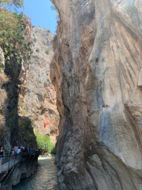 Yüksek bir kaya vadisi ve dağ nehri. Nehir boyunca derin dar bir kanyon. Türkiye 'yi gezmek, turistler için gezi. Fethiye ve Oludeniz köyleri yakınlarındaki Saklikent geçidi, 13 Ağustos 2021