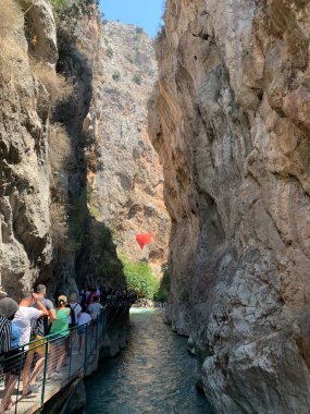Yüksek bir kaya vadisi ve dağ nehri. Nehir boyunca derin dar bir kanyon. Türkiye 'yi gezmek, turistler için gezi. Fethiye ve Oludeniz köyleri yakınlarındaki Saklikent geçidi, 13 Ağustos 2021