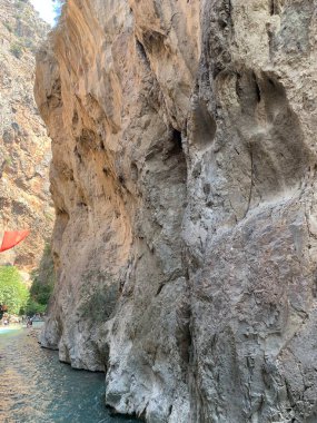 Yüksek bir kaya vadisi ve dağ nehri. Nehir boyunca derin dar bir kanyon. Türkiye 'yi gezmek, turistler için gezi. Fethiye ve Oludeniz köyleri yakınlarındaki Saklikent geçidi, 13 Ağustos 2021