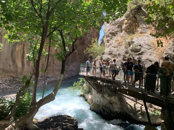 Yüksek bir kaya vadisi ve dağ nehri. Nehir boyunca derin dar bir kanyon. Türkiye 'yi gezmek, turistler için gezi. Fethiye ve Oludeniz köyleri yakınlarındaki Saklikent geçidi, 13 Ağustos 2021