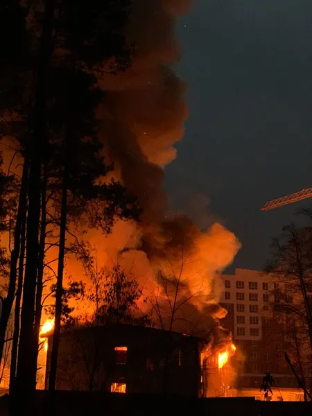A residential building is on fire at night. A big fire in the area of a high-rise building. Concept: fire safety, emergency.