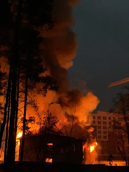 A residential building is on fire at night. A big fire in the area of a high-rise building. Concept: fire safety, emergency.