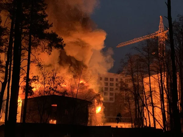 A residential building is on fire at night. A big fire in the area of a high-rise building. Concept: fire safety, emergency.