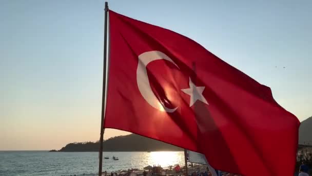 Σημαία Κυματίζει Στο Φόντο Της Θάλασσας Και Του Ήλιου Κόκκινη — Αρχείο Βίντεο