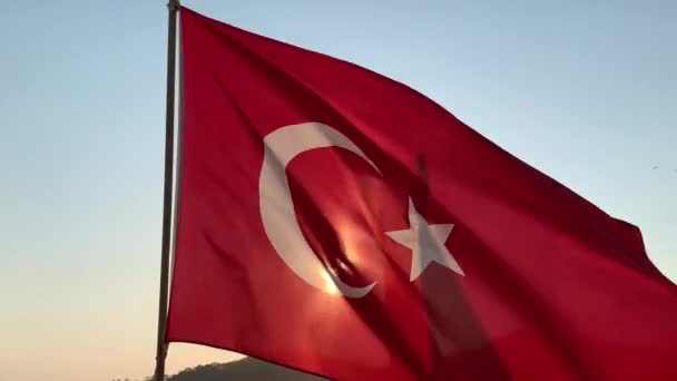 旗帜在大海和太阳的衬托下飘扬 红色土耳其国旗 风中挂着新月形月亮 土耳其 Oludeniz Mount Babadag 2021年8月8日 — 图库视频影像