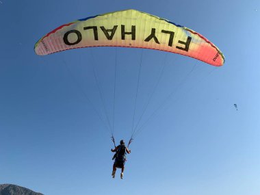 Türkiye 'de paraşütle atlama. Gökyüzünün arka planında paraşütle atlamak. Toz sporu, yamaç paraşütü. Türkiye, Babadag Dağı, Oludeniz, 8 Ağustos 2021