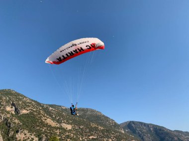 Türkiye 'de paraşütle atlama. Gökyüzünün arka planında paraşütle atlamak. Toz sporu, yamaç paraşütü. Türkiye, Babadag Dağı, Oludeniz, 8 Ağustos 2021