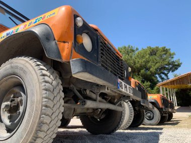 Safari turları için parlak jipler. Ekstrem maceralar için gezi arabaları. Dağlara seyahat için açık arabalar. Türkiye, Gizlikent Şelalesi yakınında bir otopark, 13 Ağustos 2021