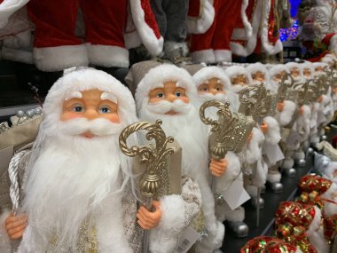 Parlak, yumuşak, yeni yıl oyuncağı Noel Baba. Noel arifesinde Noel Baba bebek bir mağazanın rafında. Tatile hazırlanmak, oyuncakçıda satmak..