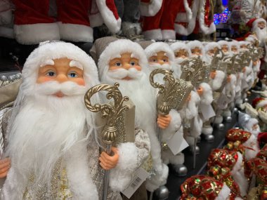 Parlak, yumuşak, yeni yıl oyuncağı Noel Baba. Noel arifesinde Noel Baba bebek bir mağazanın rafında. Tatile hazırlanmak, oyuncakçıda satmak..