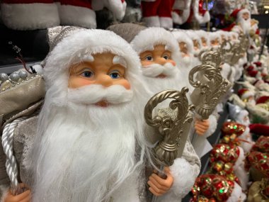 Parlak, yumuşak, yeni yıl oyuncağı Noel Baba. Noel arifesinde Noel Baba bebek bir mağazanın rafında. Tatile hazırlanmak, oyuncakçıda satmak..