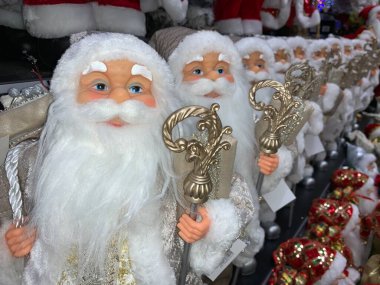 Parlak, yumuşak, yeni yıl oyuncağı Noel Baba. Noel arifesinde Noel Baba bebek bir mağazanın rafında. Tatile hazırlanmak, oyuncakçıda satmak..