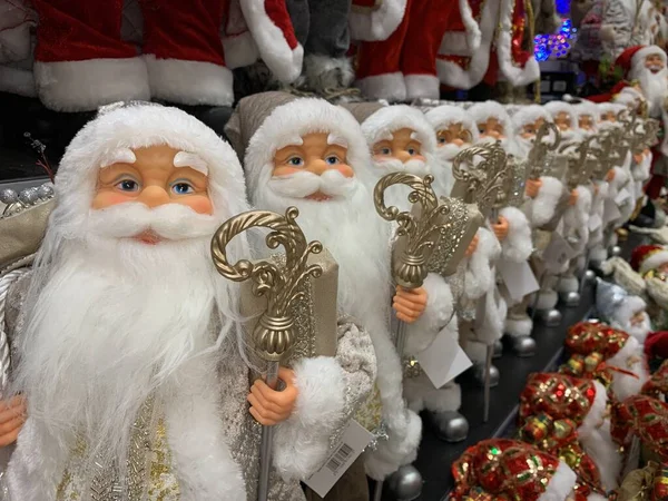 Parlak, yumuşak, yeni yıl oyuncağı Noel Baba. Noel arifesinde Noel Baba bebek bir mağazanın rafında. Tatile hazırlanmak, oyuncakçıda satmak..