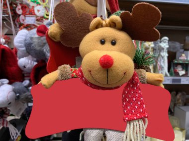 Yeni yılın yumuşak oyuncağı, boynuzlu bir geyik. Komik geyik - Noel ağacının altında bir bebek. Çocuklar için Noel hediyesi, yazıtlar için yer.