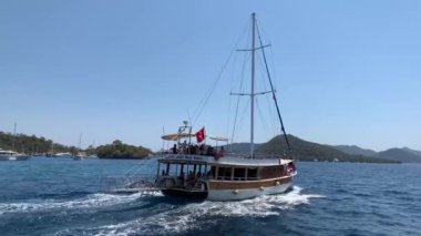 Deniz koyuna yakın lüks bir yat yelken açar. Orta karasal denizde özel bir tekne yüzüyor. Deniz kıyısına yakın denizde yelkenli bir tekne. Türkiye, Fethia, 12 ada turu, 9 Ağustos 2021.