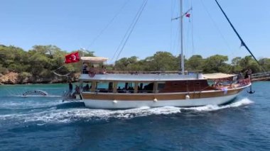 Deniz koyuna yakın lüks bir yat yelken açar. Orta karasal denizde özel bir tekne yüzüyor. Deniz kıyısına yakın denizde yelkenli bir tekne. Türkiye, Fethia, 12 ada turu, 9 Ağustos 2021.