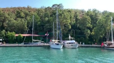 Deniz koyuna yakın lüks bir yat yelken açar. Orta karasal denizde özel bir tekne yüzüyor. Deniz kıyısına yakın denizde yelkenli bir tekne. Türkiye, Fethia, 12 ada turu, 9 Ağustos 2021.