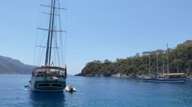 Deniz koyuna yakın lüks bir yat yelken açar. Orta karasal denizde özel bir tekne yüzüyor. Deniz kıyısına yakın denizde yelkenli bir tekne. Türkiye, Fethia, 12 ada turu, 9 Ağustos 2021.