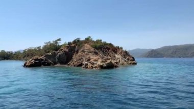 Denizde yüzen bir gemiden su akışı. Su sıçratma ve deniz hareketi, üst manzara. Yelkenli yatın yüksekliğinden deniz suyunun görüntüsü.