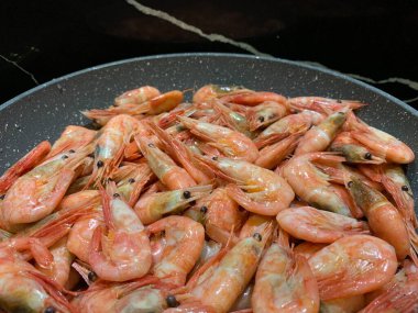 Soslu karides. Kızartma tavasında karides olan bir tabak. Baharatlı deniz ürünleri pişirmek, yakın plan..