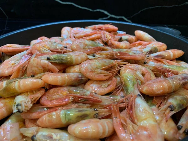 Soslu karides. Kızartma tavasında karides olan bir tabak. Baharatlı deniz ürünleri pişirmek, yakın plan..