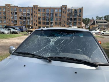 Yıkılan binaların arka planında yanmış ve bomboş bir araba. Evin kalıntıları ve arabanın gövdesinde kurşun izleri var. Rusya ve Ukrayna arasındaki savaş, Irpin-Bucha, 10 Nisan 2022