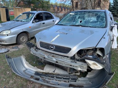 Yıkılan binaların arka planında yanmış ve bomboş bir araba. Evin kalıntıları ve arabanın gövdesinde kurşun izleri var. Rusya ve Ukrayna arasındaki savaş, Irpin-Bucha, 10 Nisan 2022