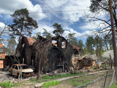 Yanmış bir araba ve yıkılmış bir bina. Bombardımandan zarar gören bir evin kalıntıları. Rusya ve Ukrayna arasındaki savaş, Irpin - Bucha, 10 Nisan 2022