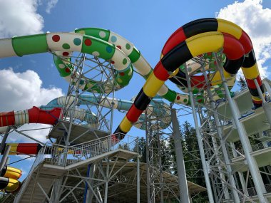 Water park slides against the blue sky. Summer Amusement Park, water attraction. Modern water park with colorful slides.