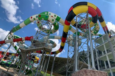 Water park slides against the blue sky. Summer Amusement Park, water attraction. Modern water park with colorful slides.